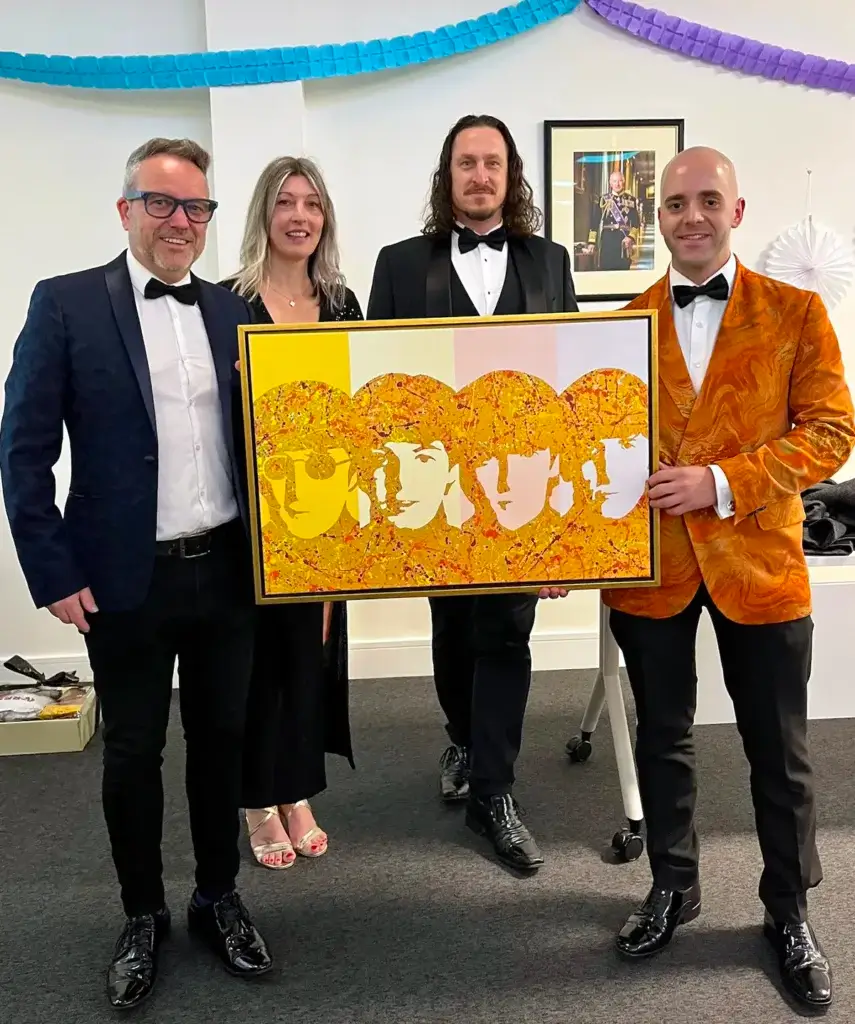Kerwin Blackburn donating his Beatles pop art print at the Broadland Council charity auction in Norwich, April 2025